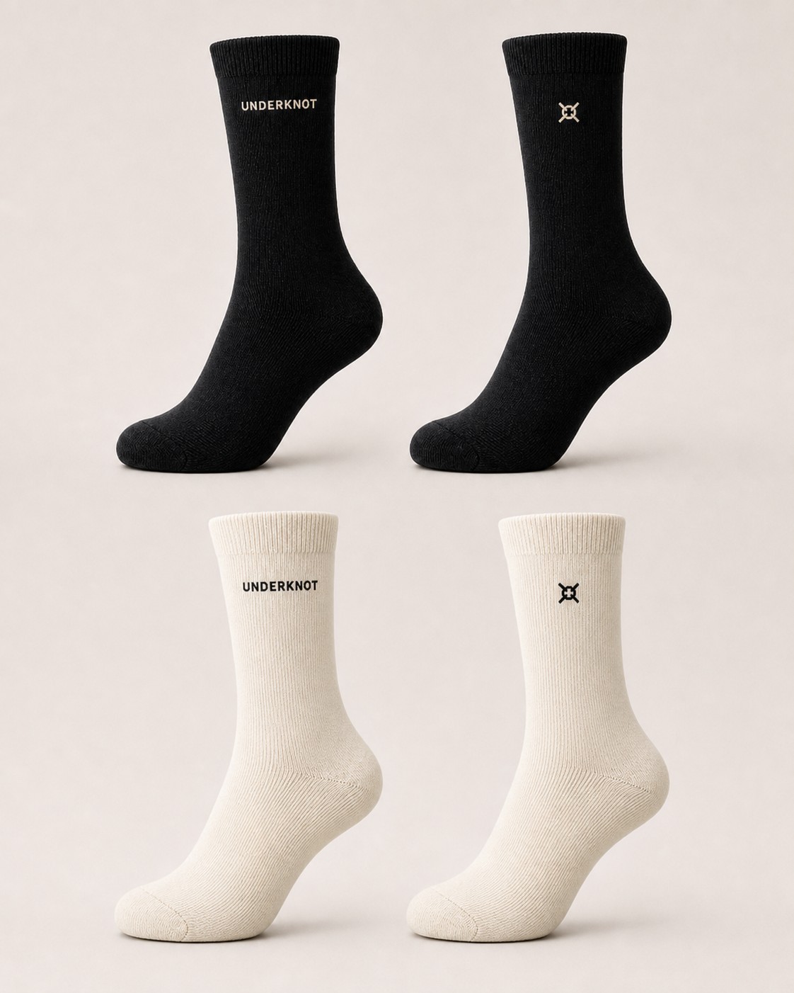 Unisex UNDERKNOT Crew Socks development concept in black and off-white, each shown with small cuff embroidery options using the UNDERKNOT wordmark or knot emblem; final details may change